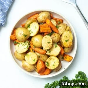 Crispy Roasted Carrots and Potatoes with Garlic and Herbs 2 Bowl of roasted potatoes and carrots topped with fresh parsley.