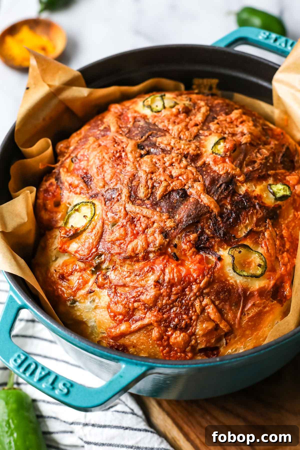 Loaf of cheddar jalapeno sourdough bread in a dutch oven.