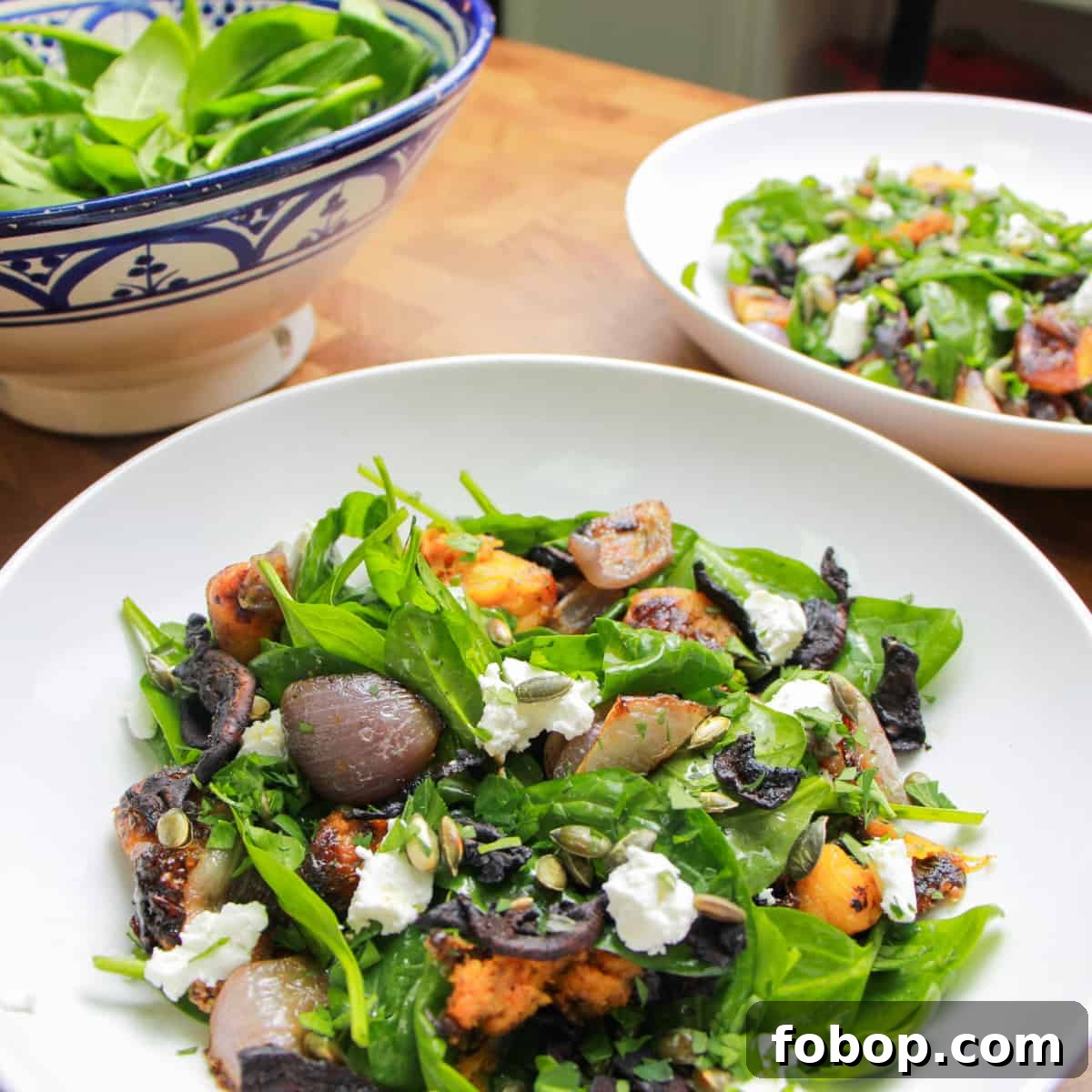 Spinach & Butternut Squash Salad with Smoky Mushroom Bacon and Vegan Feta 12 bowl of spinach, squash and mushroom bacon salad with another bowl of it behind and a bowl of spinach in the background.