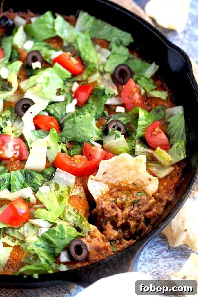 Close up of a chip scooping taco dip
