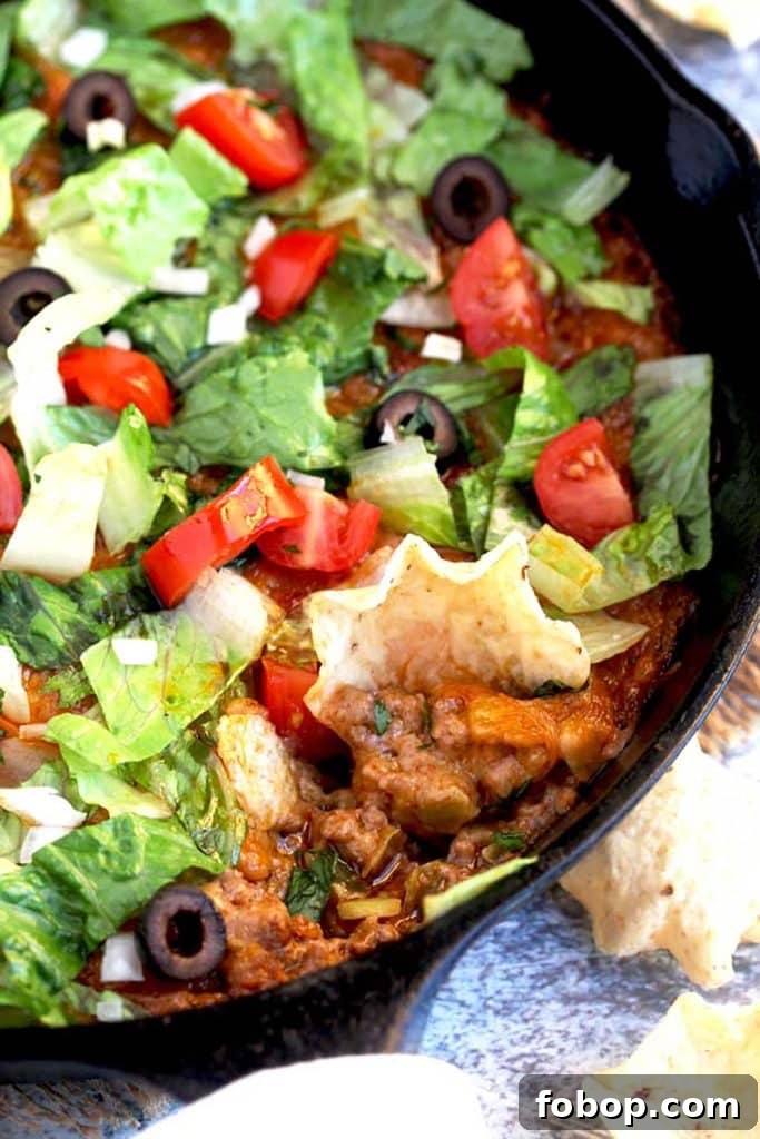 Taco Dip scooped with a tortilla chip.