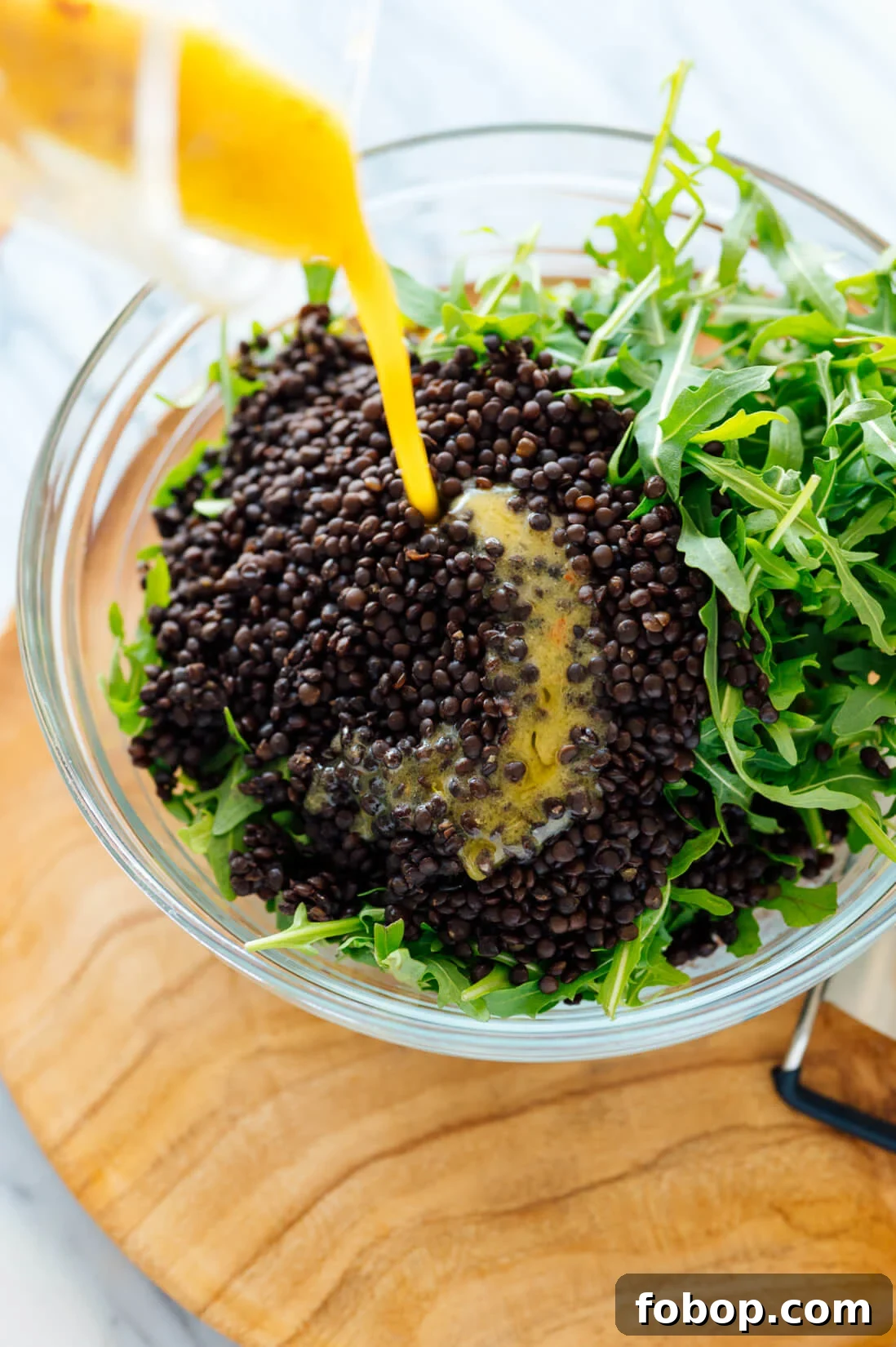 Lemony Roasted Broccoli, Arugula & Lentil Salad Recipe 7 drizzling lemon dressing over salad