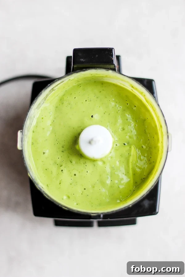 The creamy avocado sauce in a small food processor.