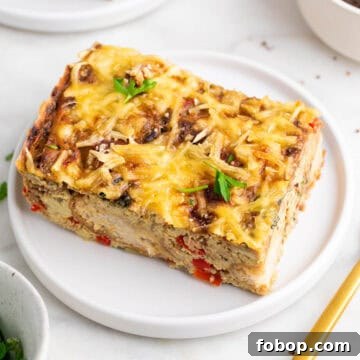Slice of vegan breakfast casserole on a plate garnished with parsley.