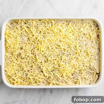 Breakfast casserole topped with vegan cheese before baking.