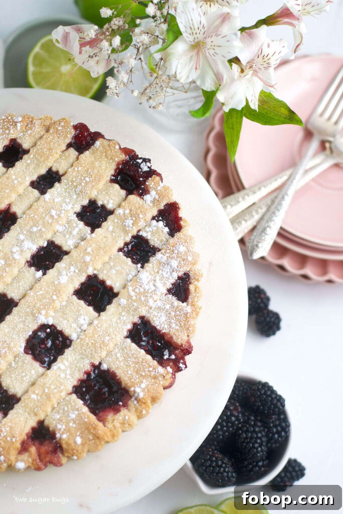 Blackberry Crostata Recipe: Rustic Tart with Fresh Berries 2 blackberry crostata on a serving plate with plates and forks