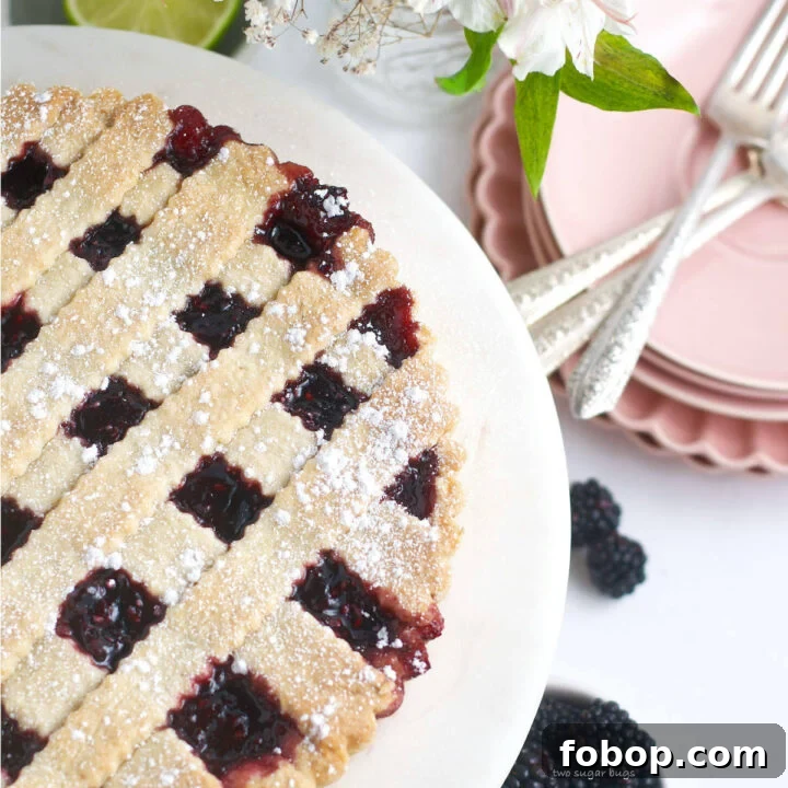 blackberry crostata on a serving plate with plates and forks