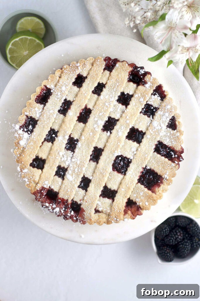Blackberry Crostata Recipe: Rustic Tart with Fresh Berries 5 blackberry crostata on a serving plate with a cup of blackberries and limes