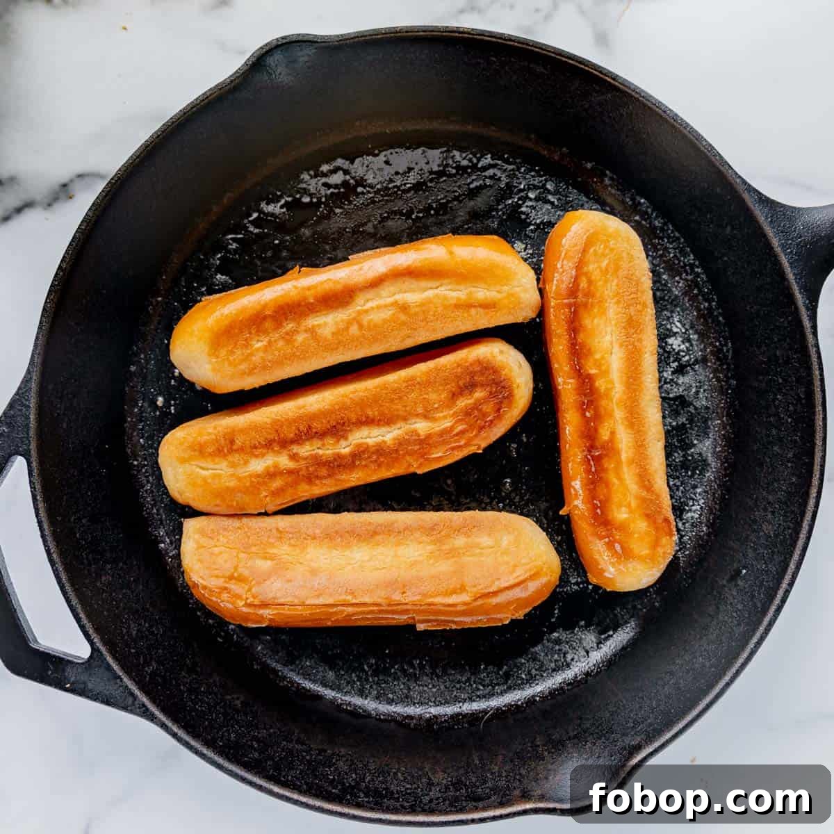 Classic Maine Lobster Roll Recipe: How to Make Authentic Lobster Rolls 9 Browned hot dog rolls in a cast iron skillet.
