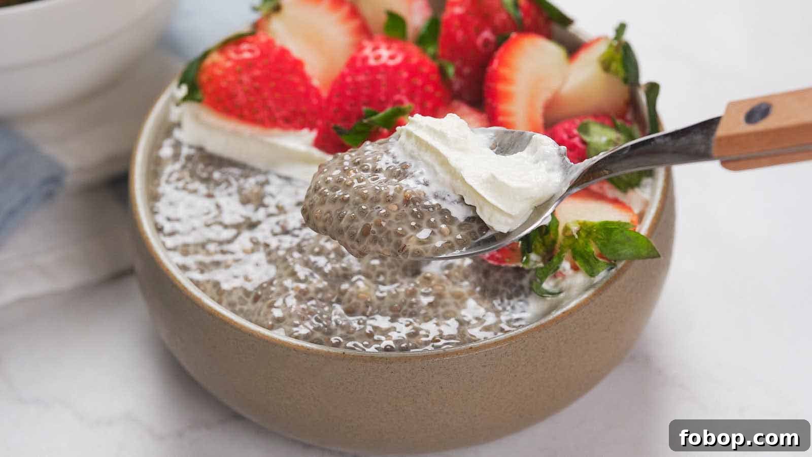 13 Delicious Low-Carb Snacks That Beat Potato Chips 11 A bowl of chia pudding topped with sliced strawberries and a dollop of whipped cream, with a spoon lifting a portion.