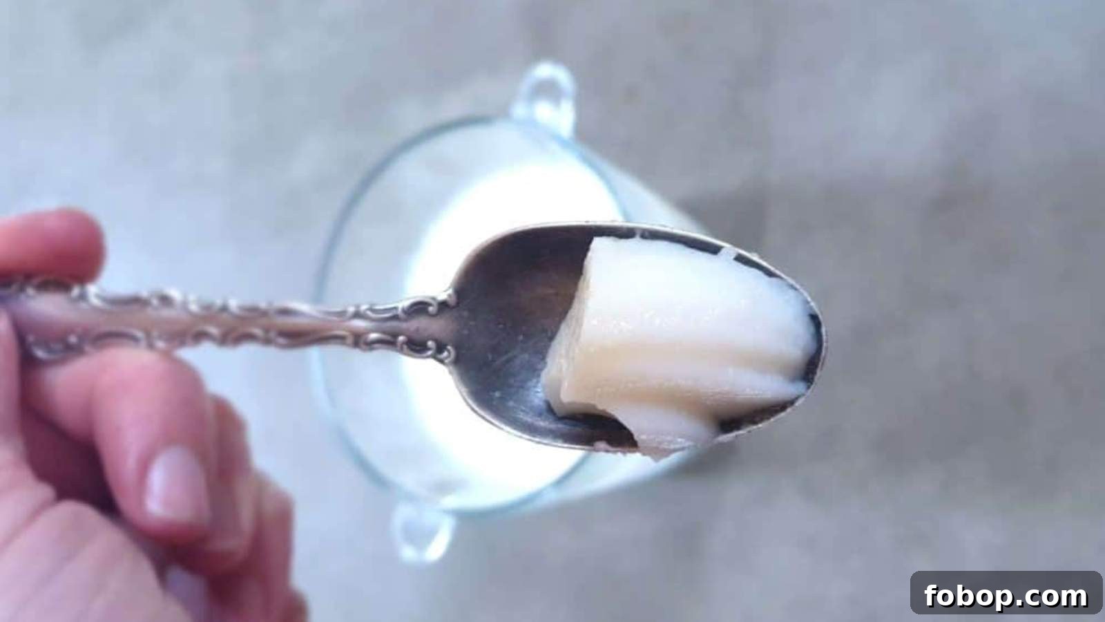 13 Delicious Low-Carb Snacks That Beat Potato Chips 14 A hand holds a spoon with a bite of cheesecake pudding above a glass bowl.