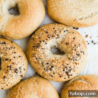Vegan Gluten-Free Bagel Recipe: Soft Homemade Bagels 8 Bagels topped with seeds on a piece of parchment paper.