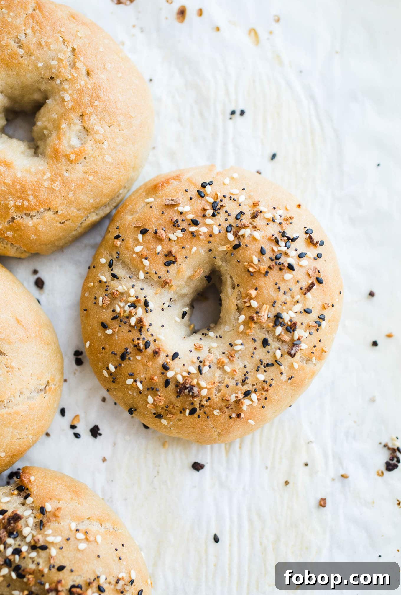 Vegan Gluten-Free Bagel Recipe: Soft Homemade Bagels 7 Everything bagels on parchment paper.