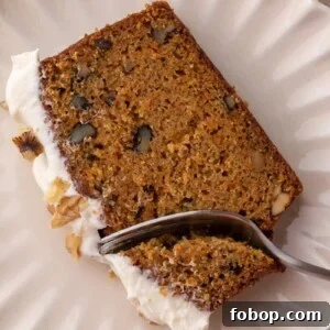 Moist Carrot Loaf Cake Recipe with Oil (Loaf Pan Method) 14 Slice of carrot loaf with walnuts and cream cheese frosting on a plate