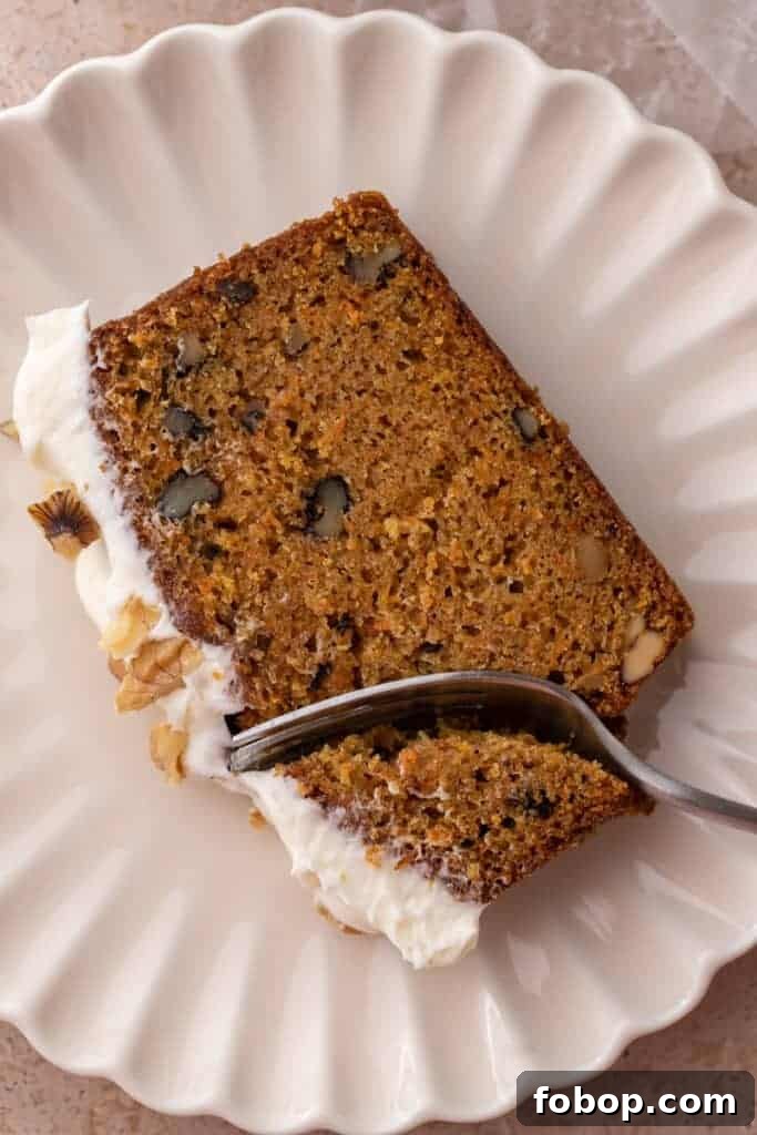 Moist Carrot Loaf Cake Recipe with Oil (Loaf Pan Method) 4 Slice of loaf cake with cream cheese frosting and walnuts on a plate