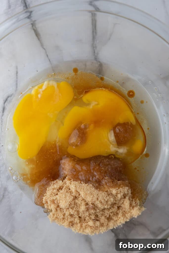 Moist Carrot Loaf Cake Recipe with Oil (Loaf Pan Method) 6 Eggs, brown sugar, oil, and vanilla in a mixing bowl.
