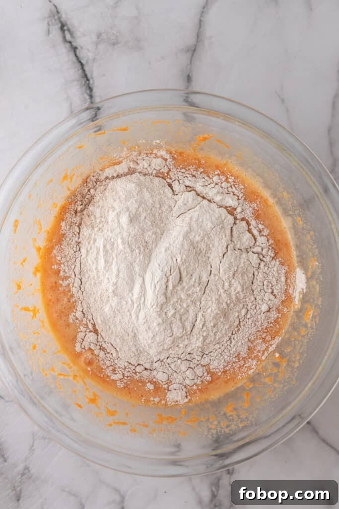 Moist Carrot Loaf Cake Recipe with Oil (Loaf Pan Method) 7 Flour added to cake batter in mixing bowl