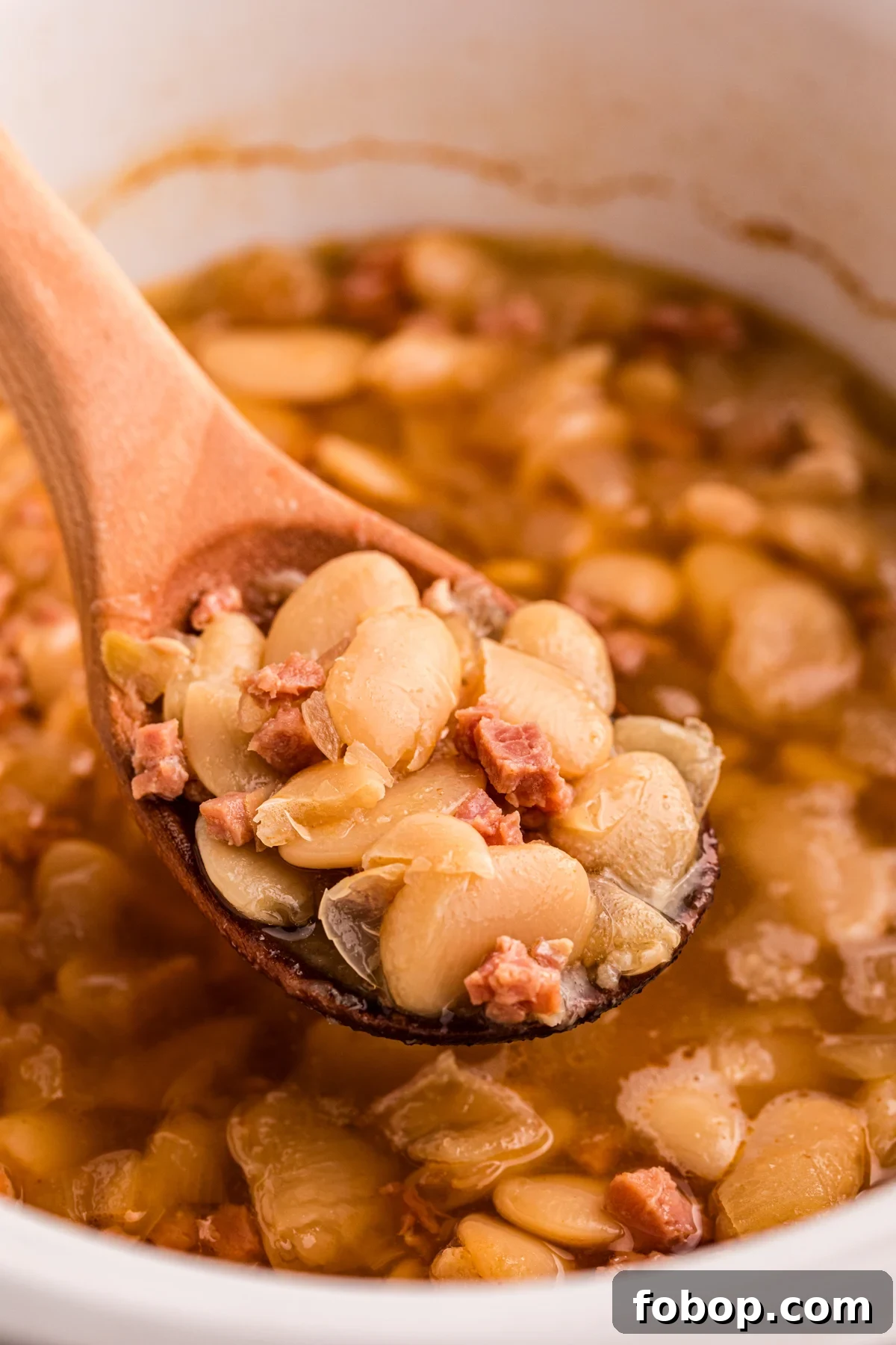 Creamy Slow Cooker Lima Beans Recipe for Weeknight Dinners 2 scooping lima beans out of a crockpot.