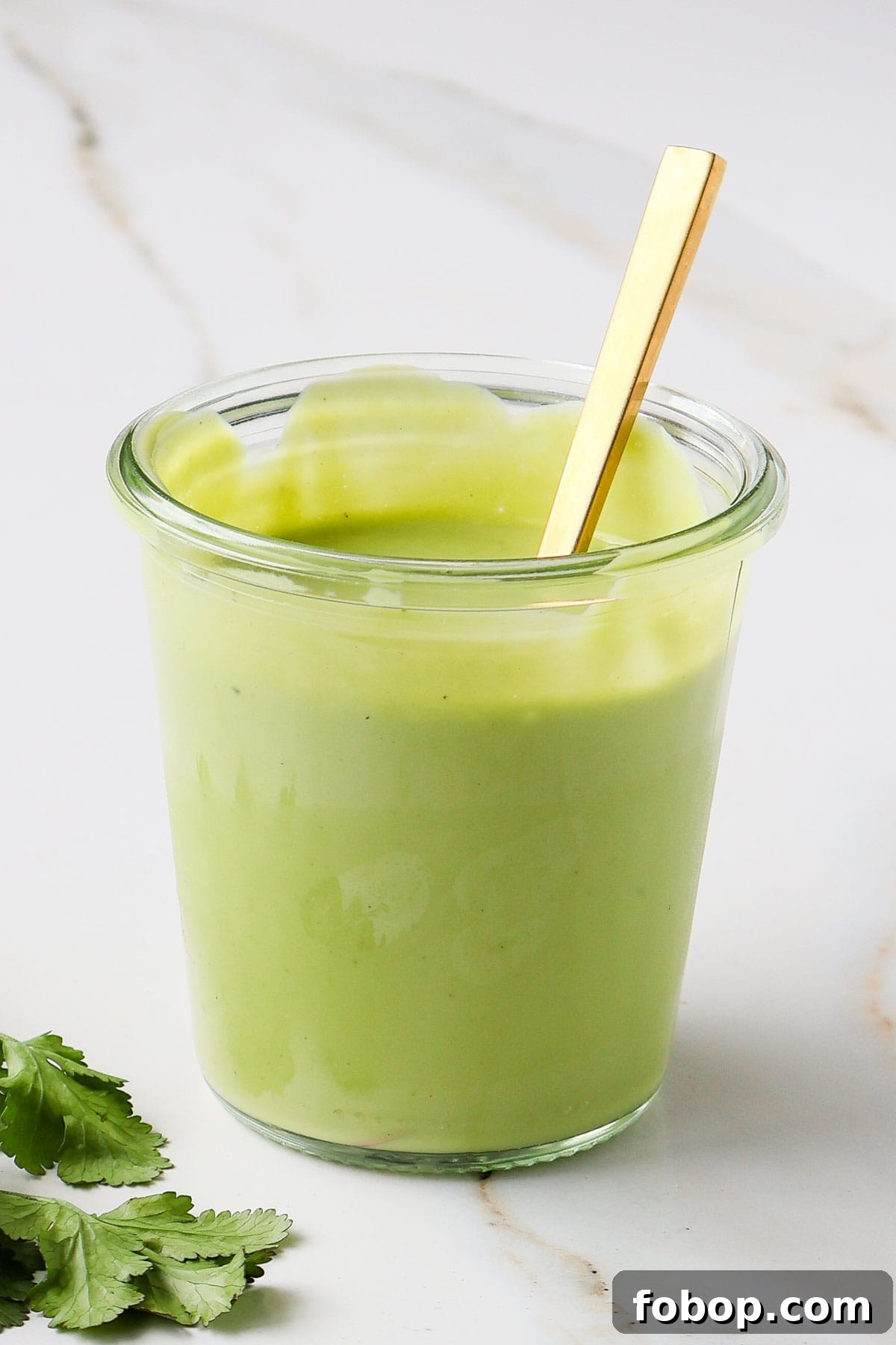 Side shot of dressing in a jar with herbs.