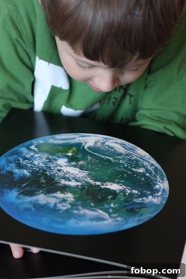 young boy looking at satellite picture of planet Earth