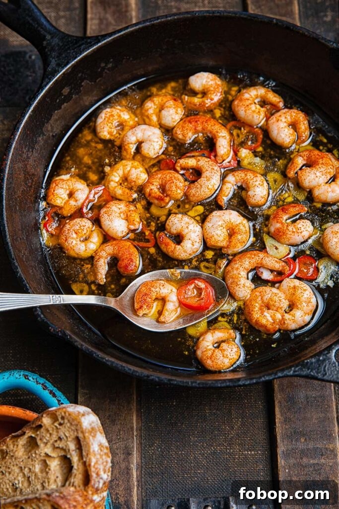 Top down shot of gambas pil pil i a pan with a serving spoon