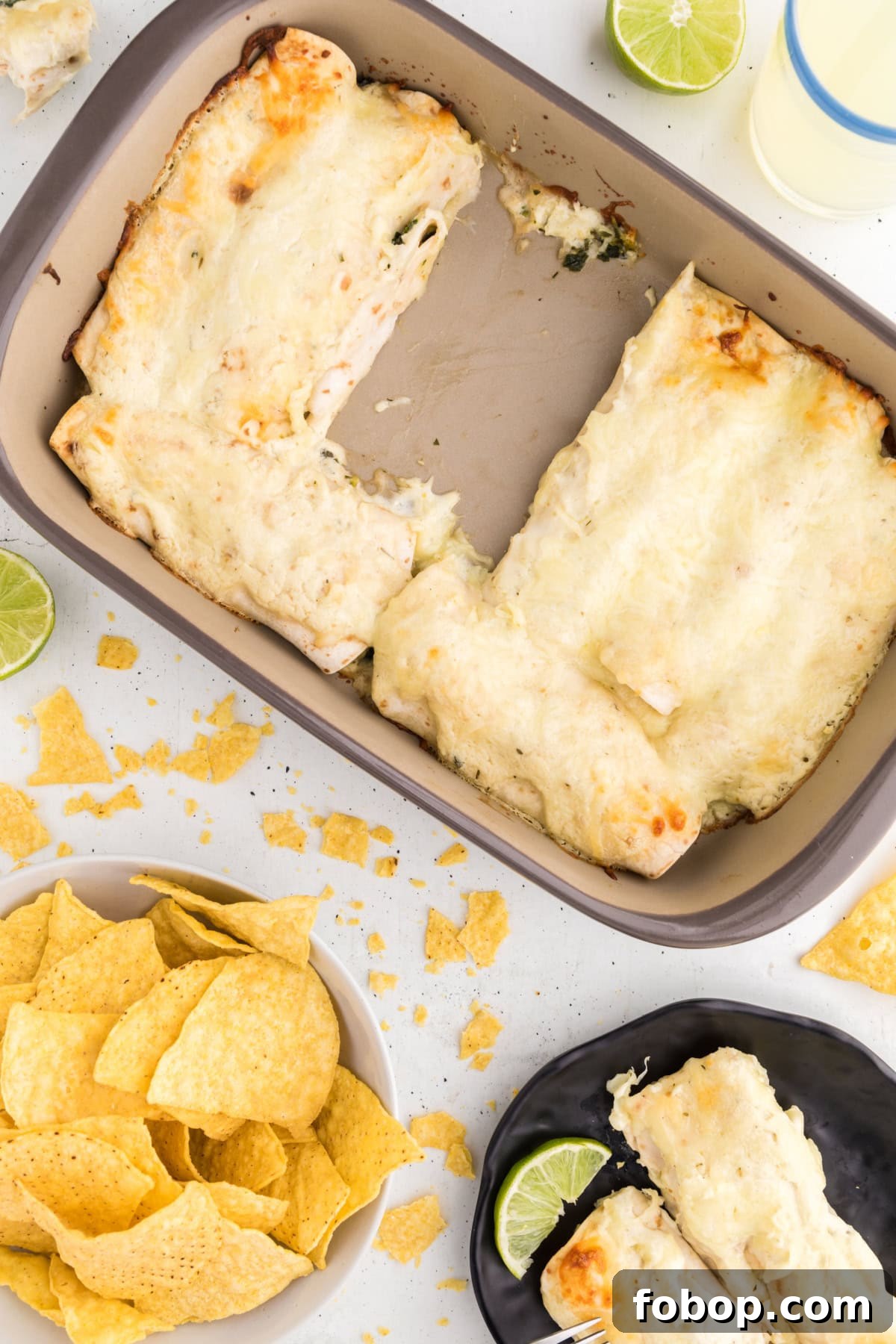 Pan of Creamy Chicken, Spinach & Mushroom Enchiladas overhead shot of pan of creamy chicken enchiladas with serving on plate