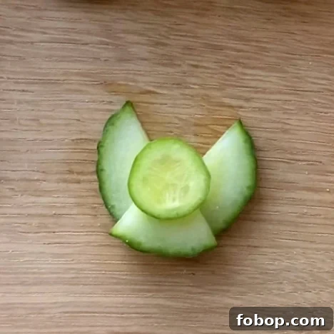 Cucumber slices arranged as an angel on a wooden surface.