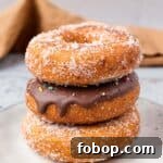 Gluten Free Donuts (Fried, Bakery Style) stacked on top of each other with chocolate frosting and sugared outsides