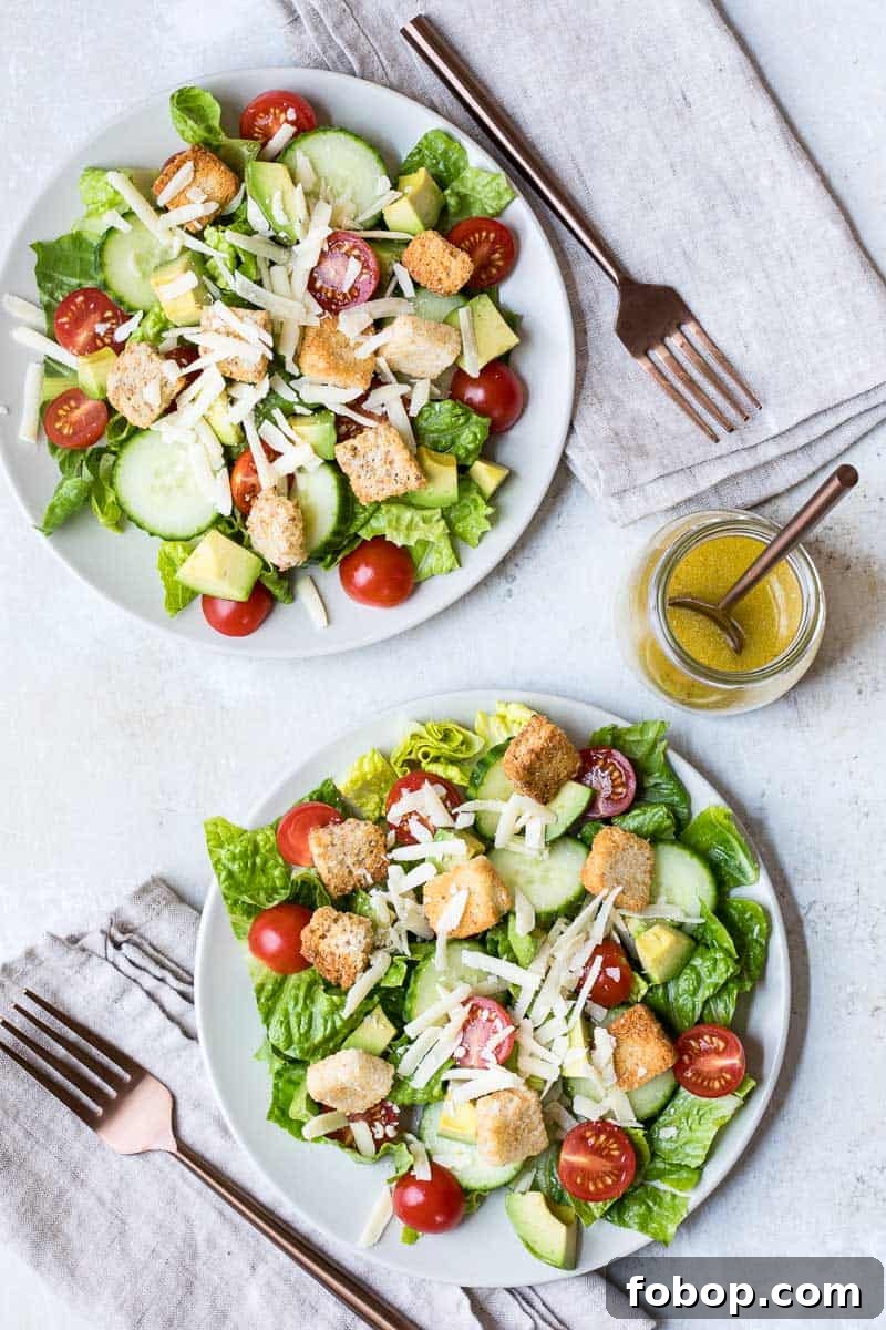 Perfect Side Salad Recipes to Complement Any Meal 2 overhead shot of two plates of accompaniment salad next to jar with vinaigrette and two napkins and two forks.