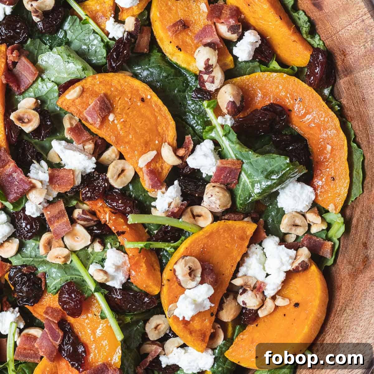 close up shot of kale butternut squash salad with hazelnuts and bacon.