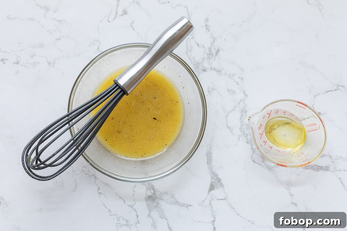 Perfect Side Salad Recipes to Complement Any Meal 6 bowl with red wine vinaigrette, whisk, and small measuring cup with a tiny amount of olive oil in it.