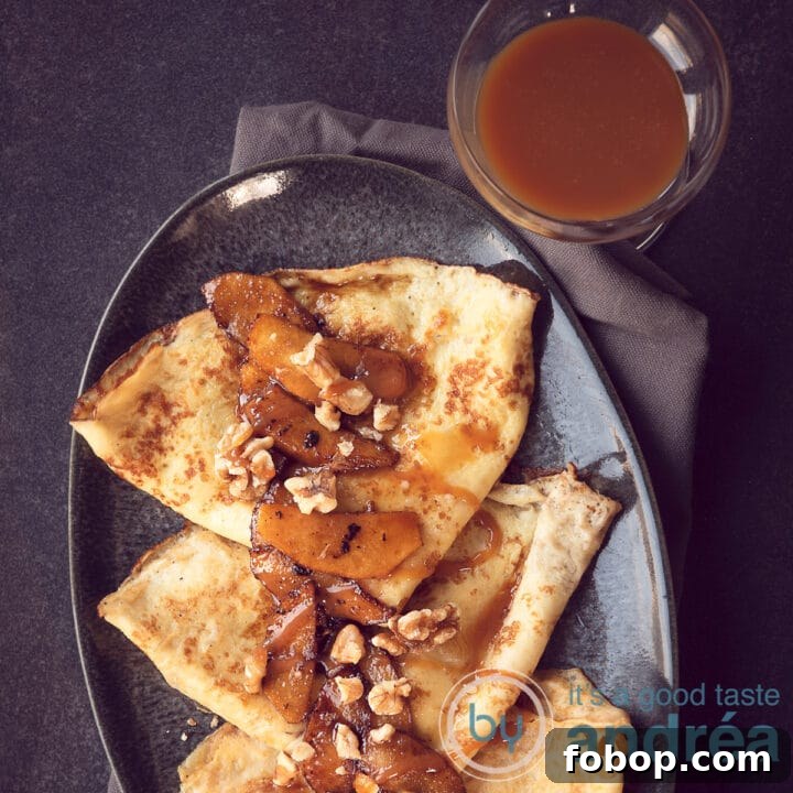 Een vierkante foto met een deel van een grijze schaal met een drietal pannekoekjes, karamelsaus en appeltjes.