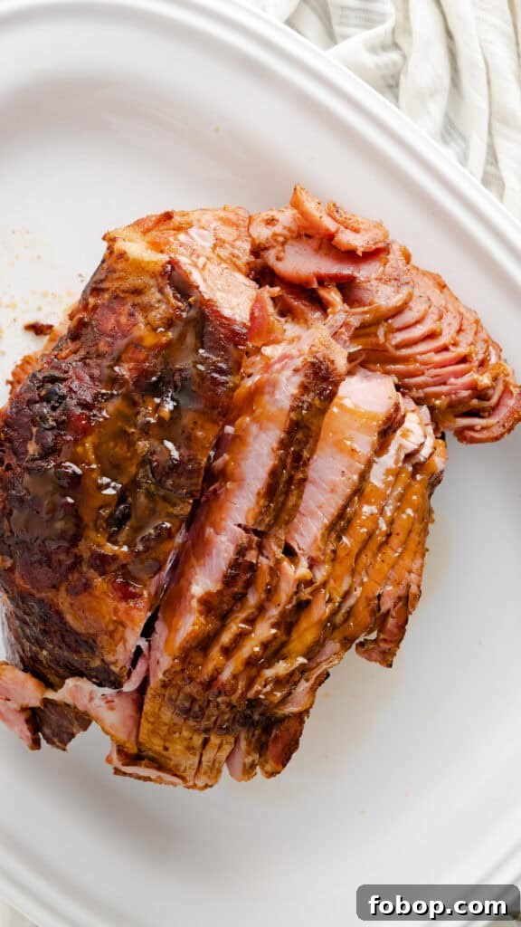 Top view of honey baked ham on white serving dish.