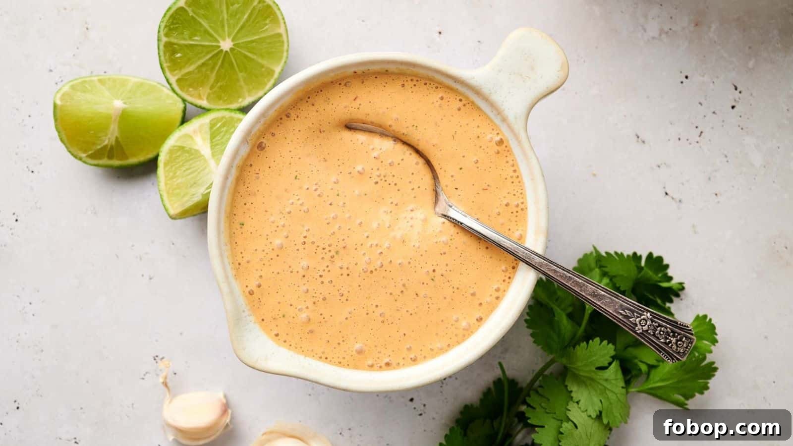 Creamy chipotle sauce with lime and herbs on a bright background.