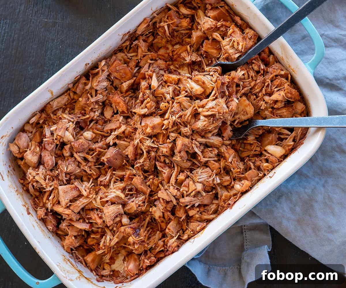 blue pan with two forks and smoked BBQ jackfruit.